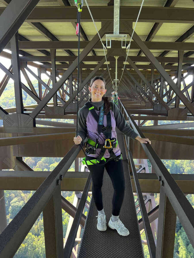 Walker harnessed on the catwalk high above the gorge
